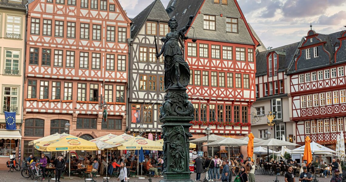 Belebter Roemerberg mit Gerechtigkeitsbrunnen und Aeppelwoi-Gastro in Frankfurt
